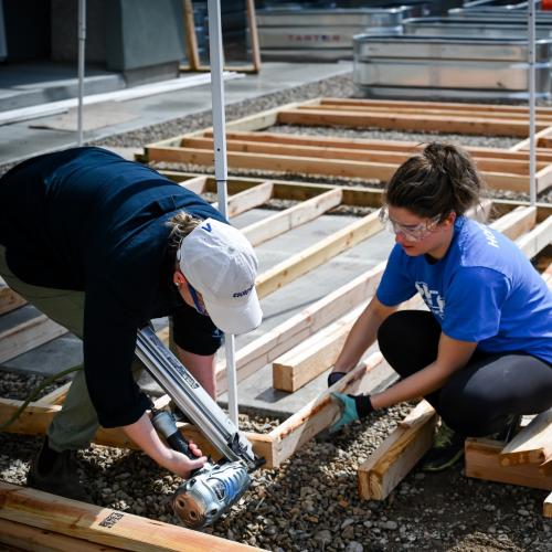 Image of two women building a frame wall.